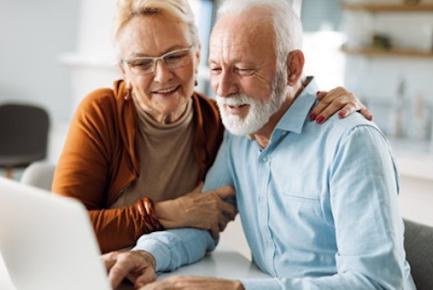 Deux retraités regardent un ordinateur